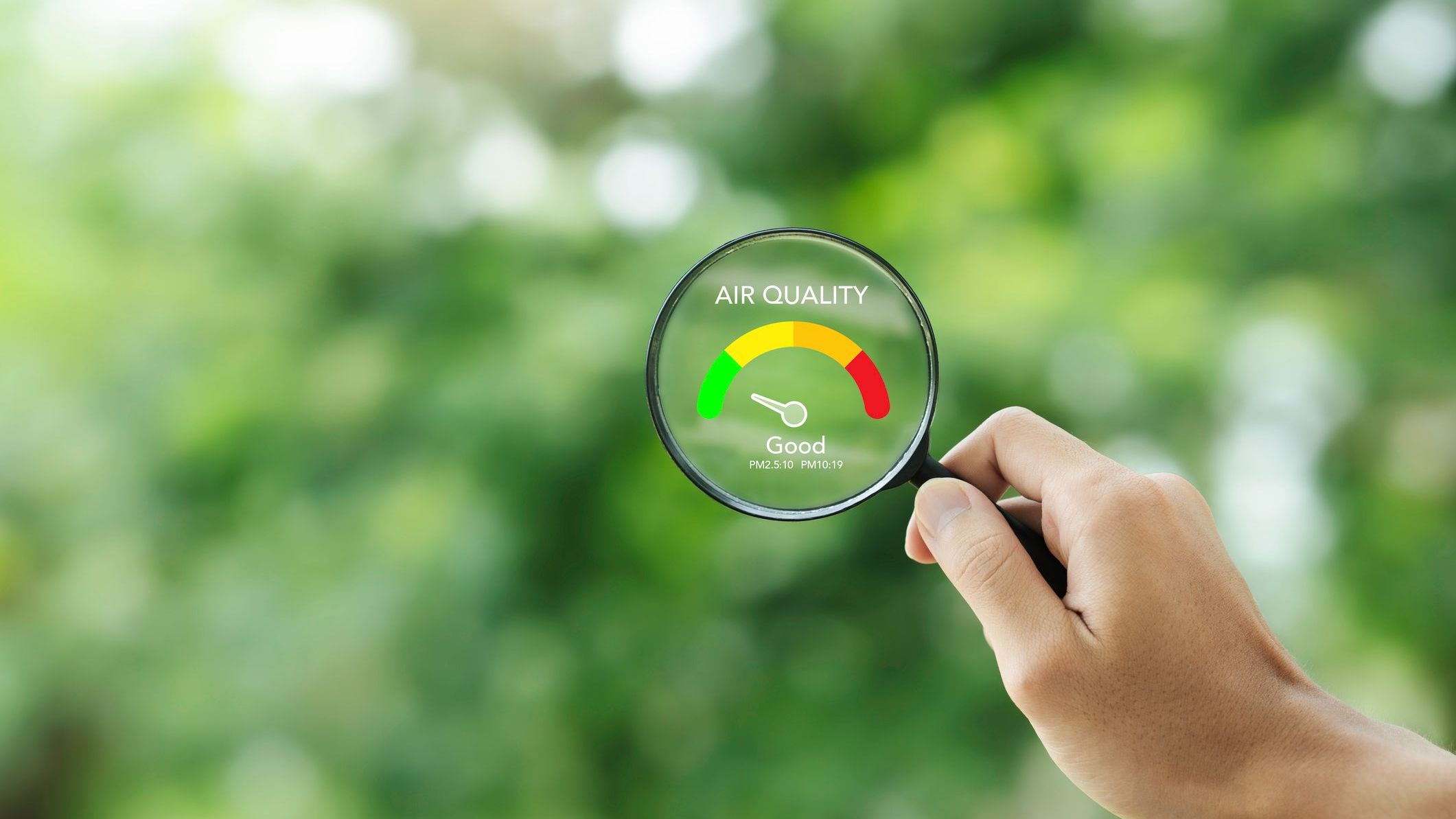 Hand holding a magnifying glass to check the good air quality and clean outdoor air quality safe from pollution dust PM 2.5