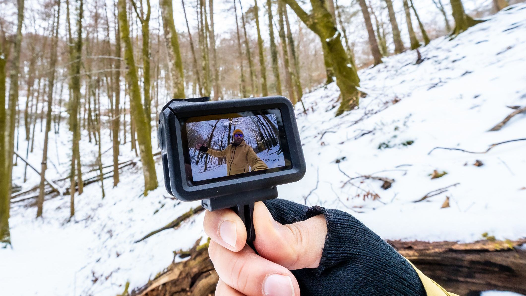 Person holding action camera recording winter selfie video