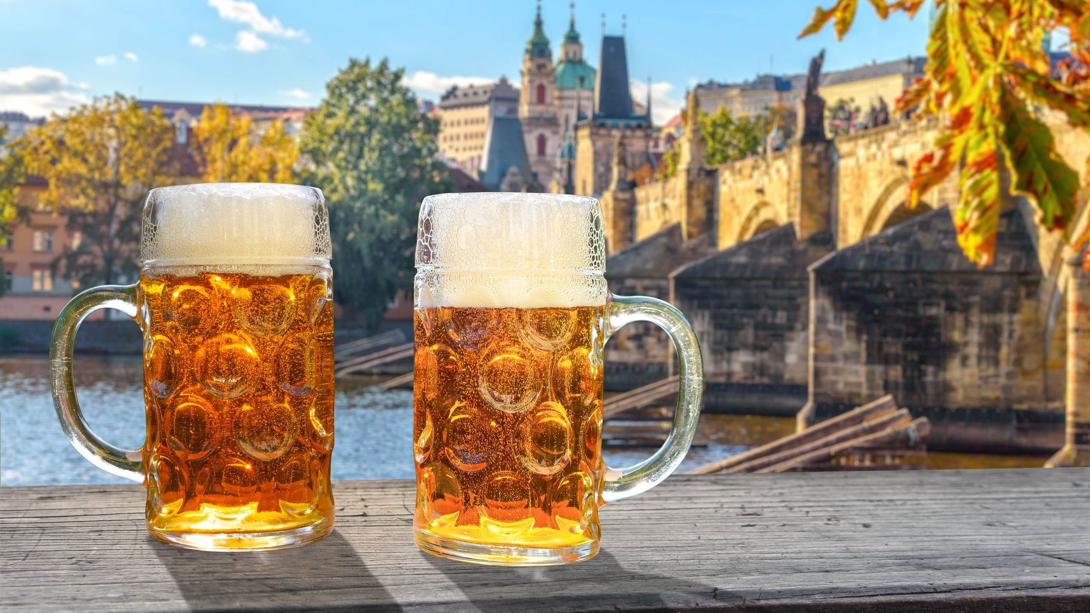 2 glasses of beer in the sunlight, in the background the view of Prague