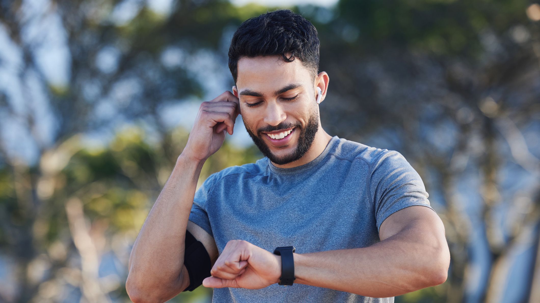 Man, runner and smartwatch outdoor for workout listening to music, radio or streaming on web. Training, running and fitness for guy with tec