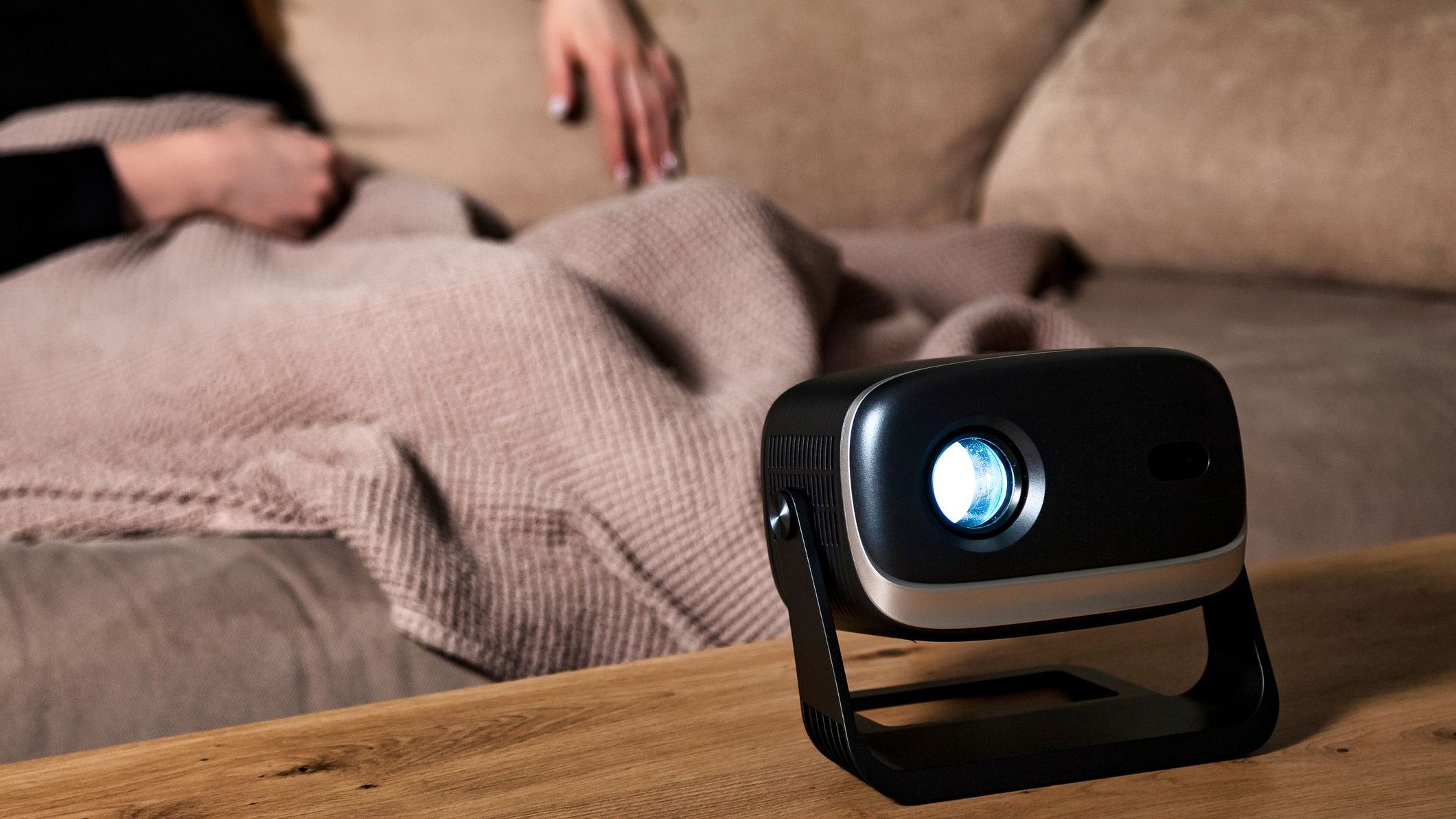 Projector Casts Light While Woman Relaxes on Couch in Living Room