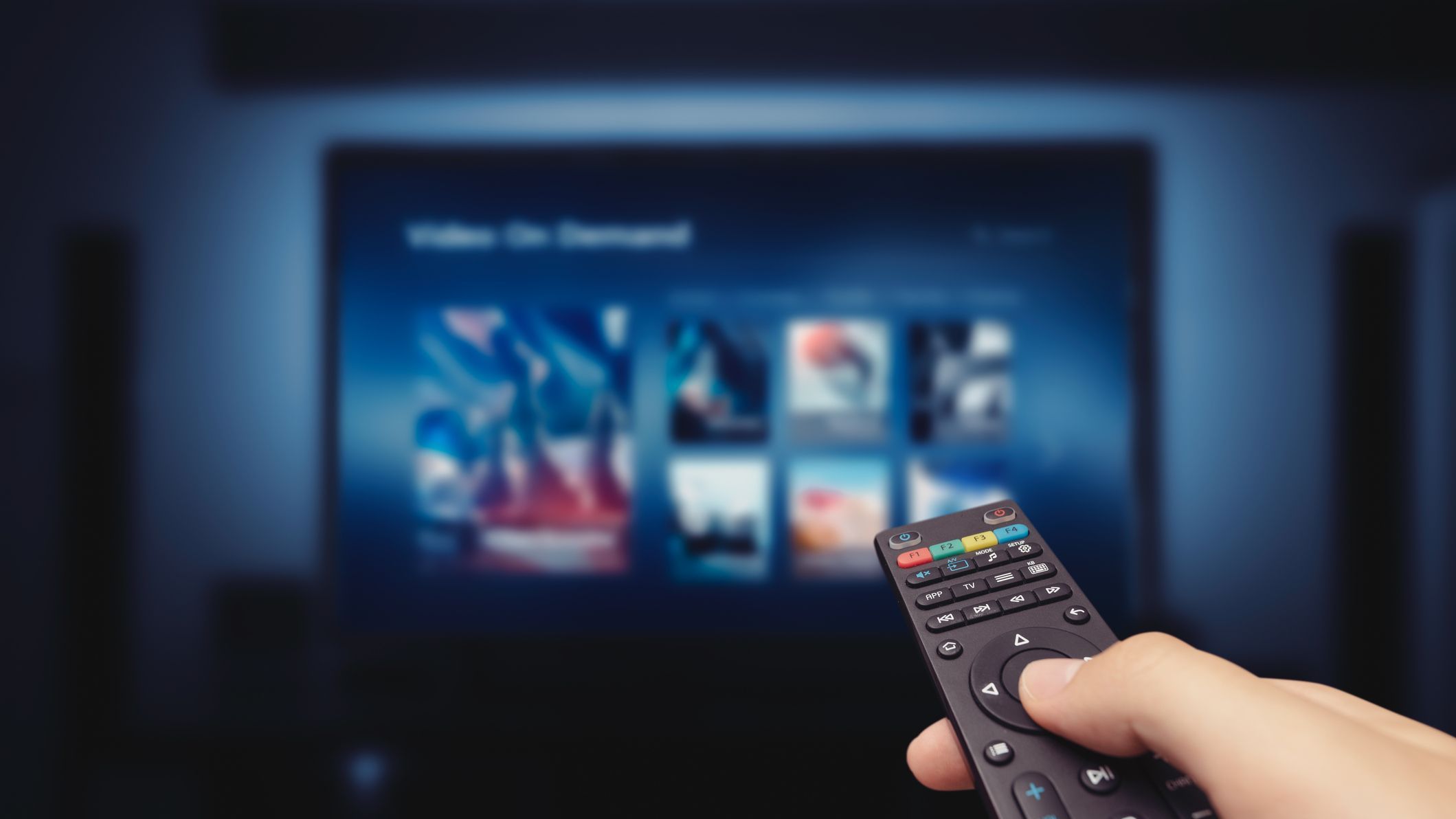 VOD service screen with remote control in hand. Video On Demand television internet stream multimedia concept