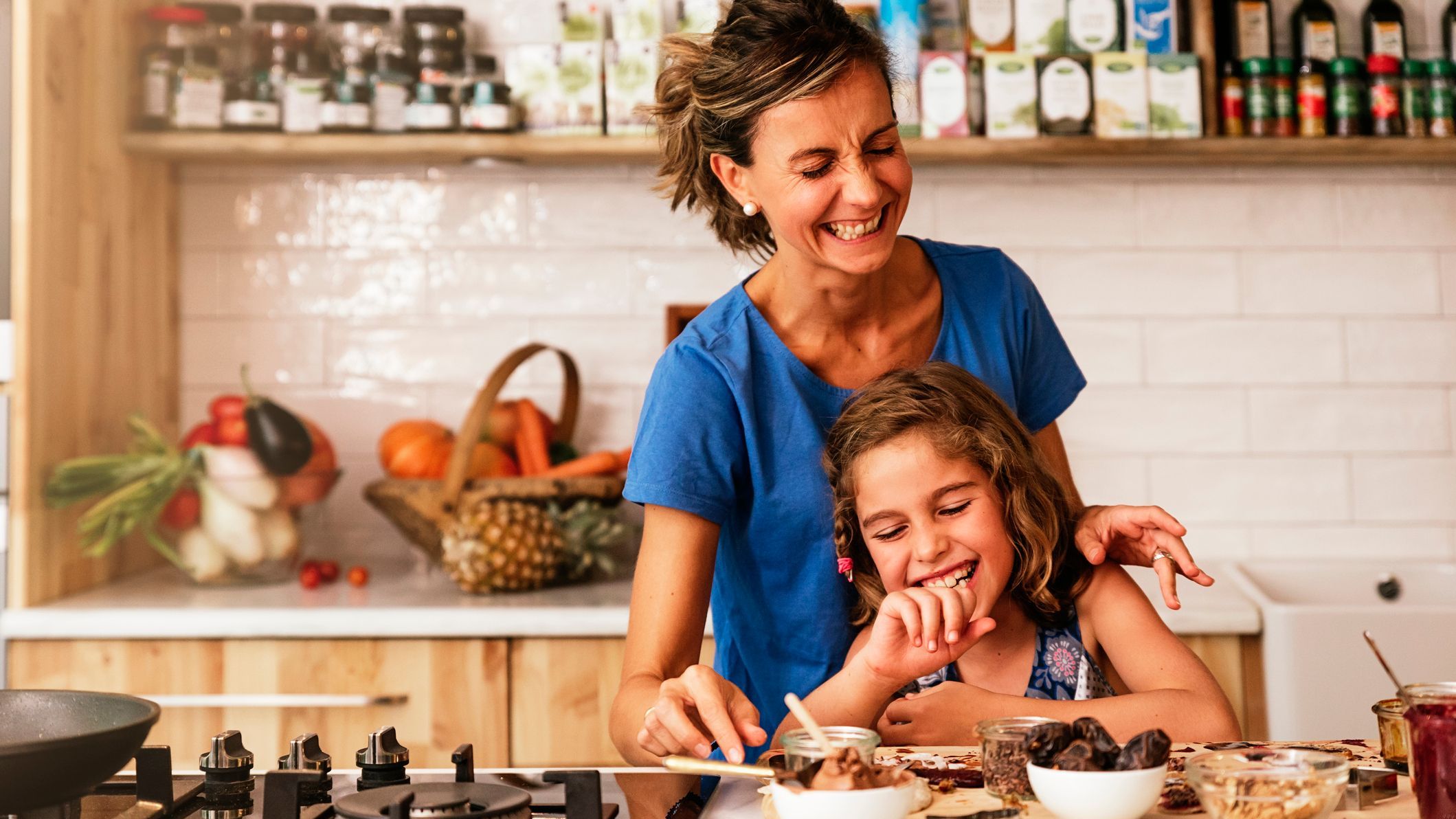 Little girl cooking with her mother in the kitchen. Infant Chef Concept.