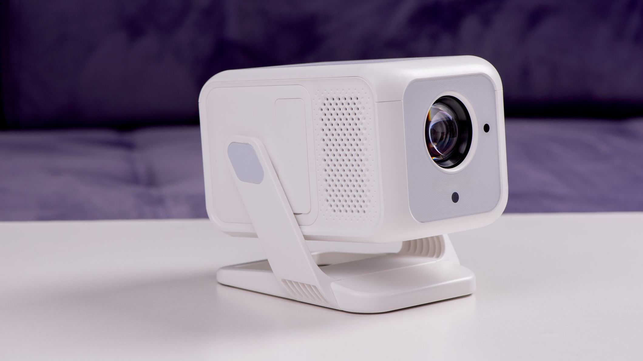 Modern White Portable Home Projector on Stand with Lens Close-Up in Minimalist Interior Setting. 4K Wifi Bluetooth Smart Projector with an a