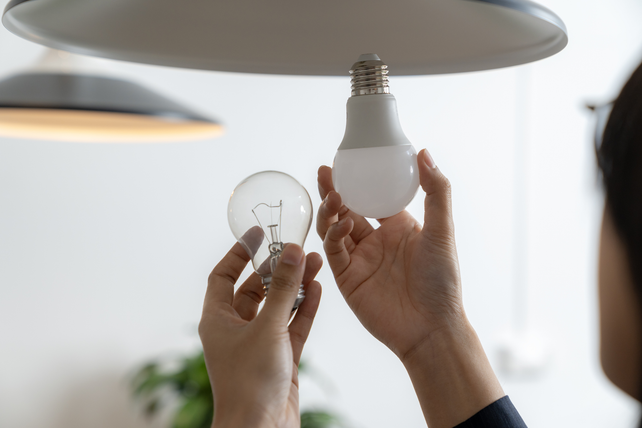 en person skifter pærer i en lampe