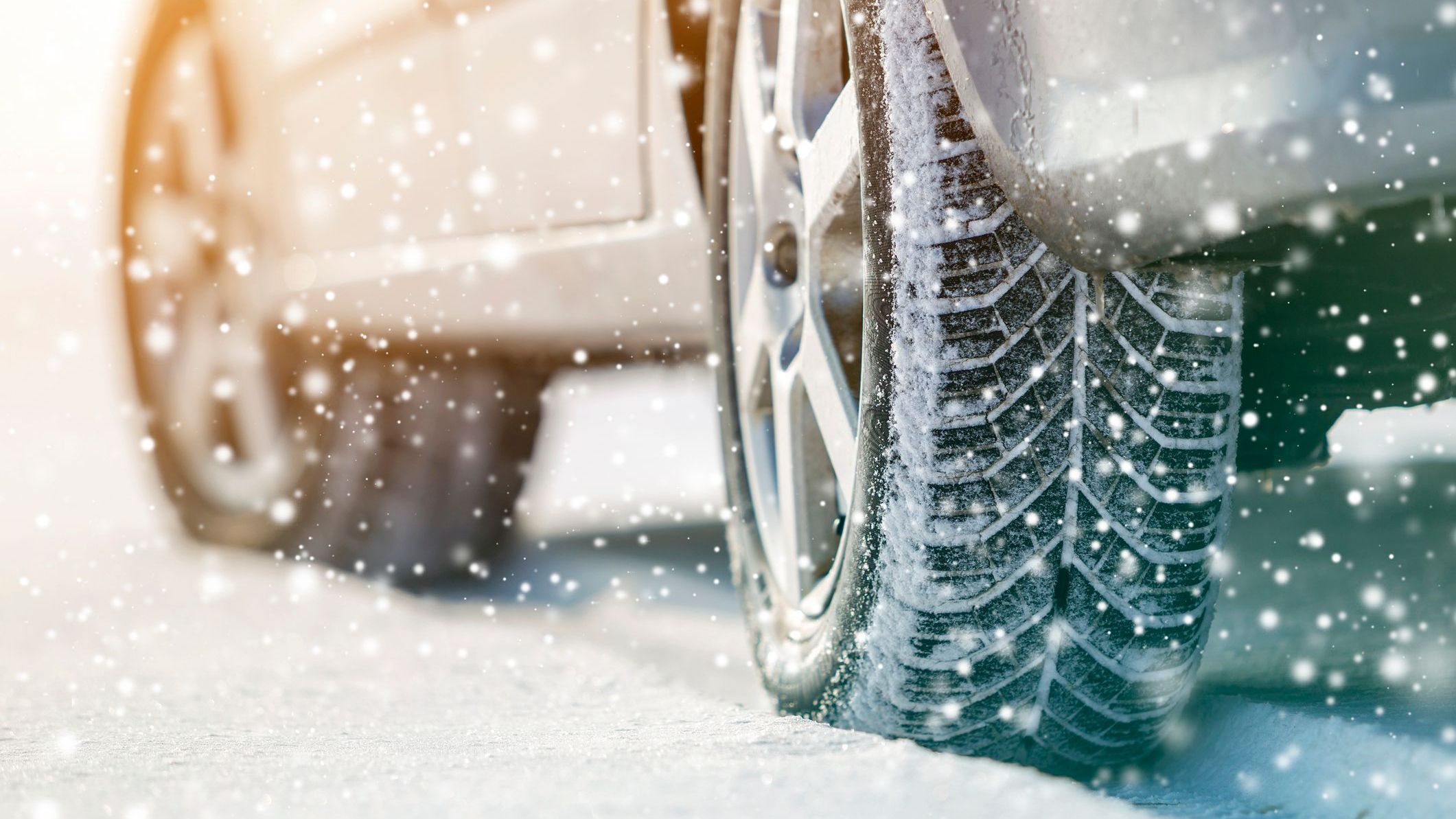 Close-up of car wheels rubber tires in deep winter snow. Transportation and safety concept