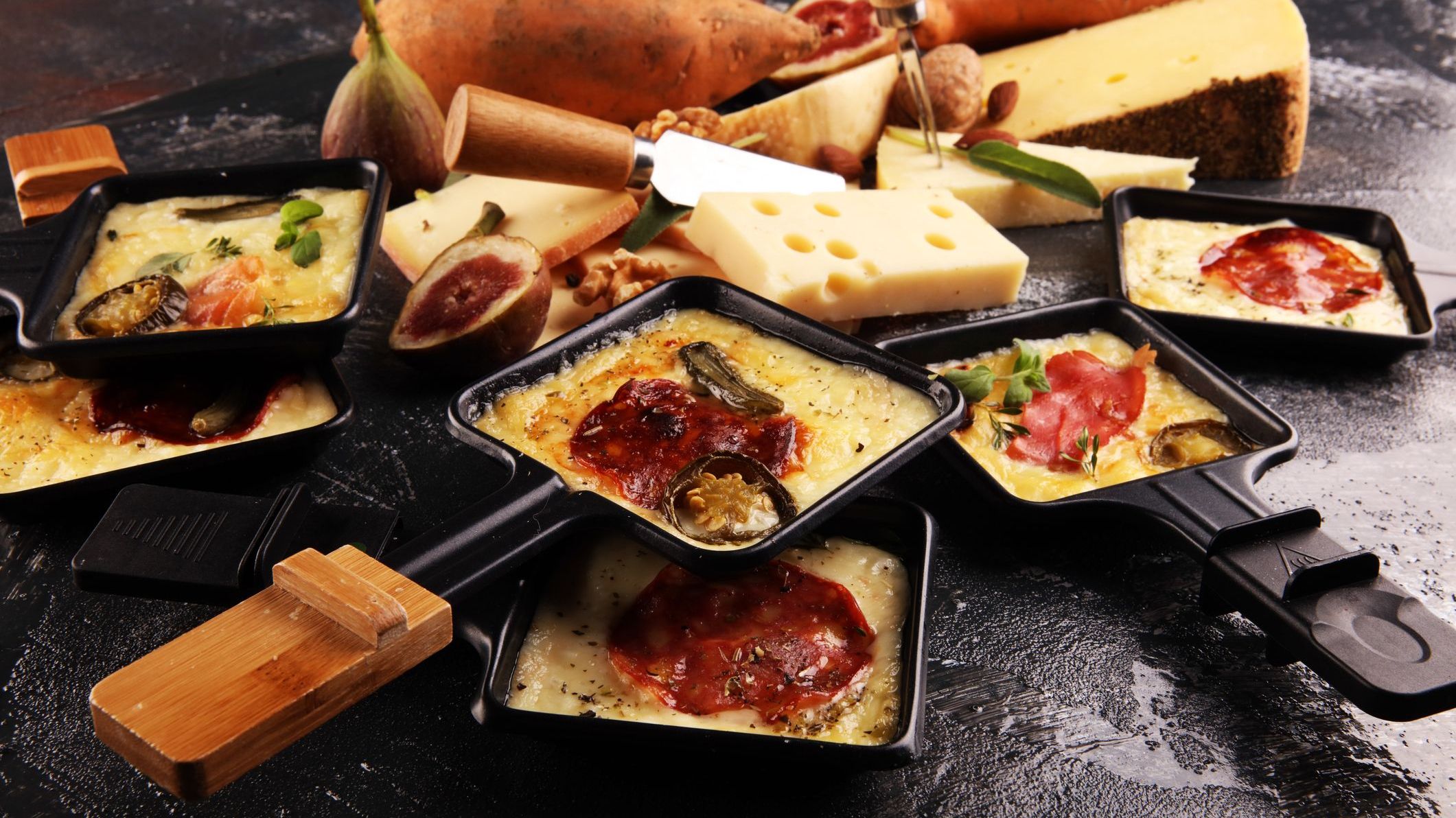 Delicious traditional Swiss melted raclette cheese on diced boiled or baked potato