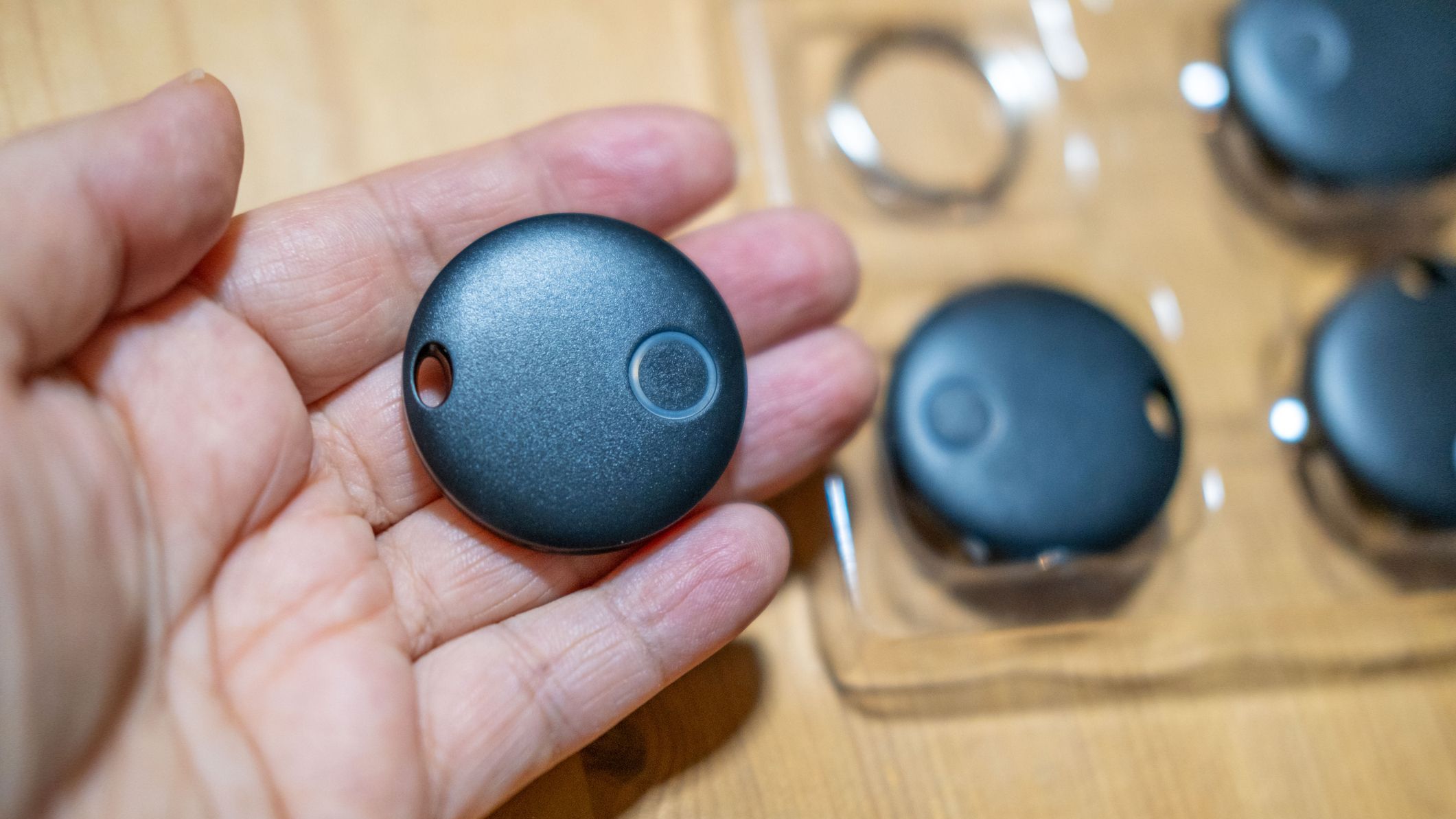 Hand holding smart tracker device, symbolizing personal item tracking and loss prevention, security and peace of mind through item tracking,