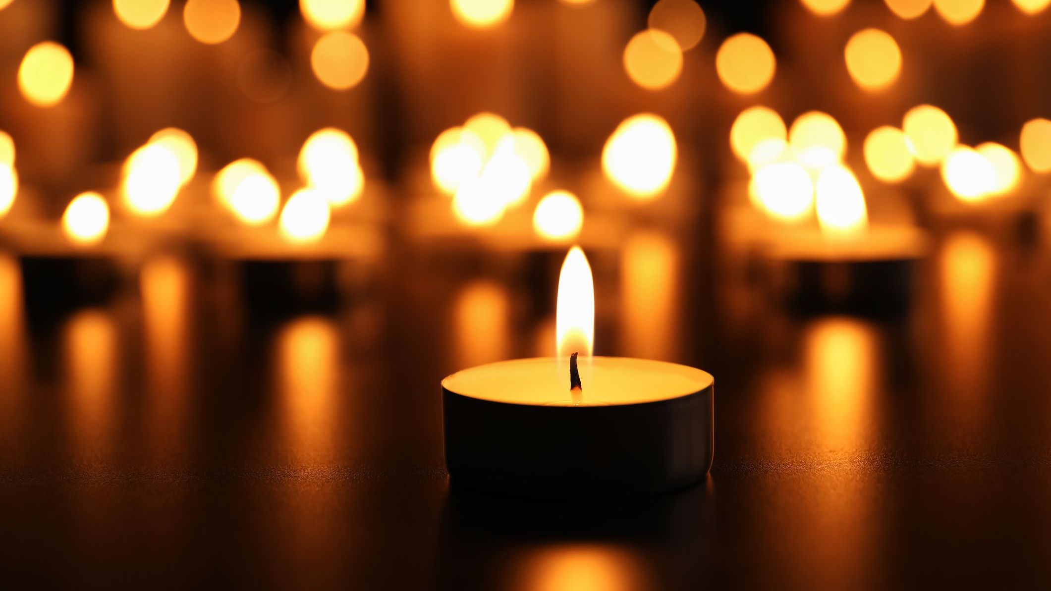 Burning candle on black table. Memory day