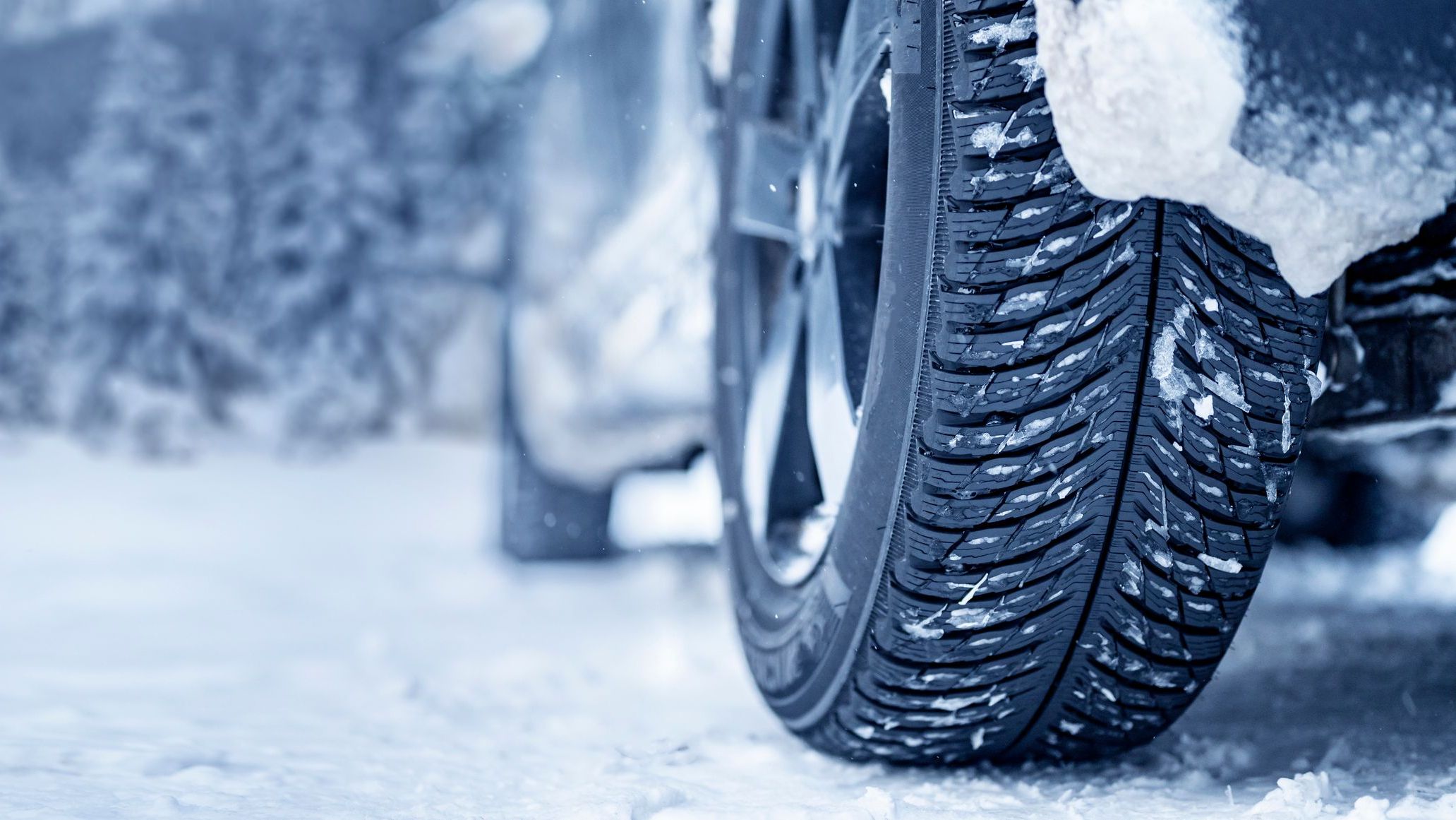 Winter tire. Detail of car tires in winter on the road covered with snow. Panorama, banner