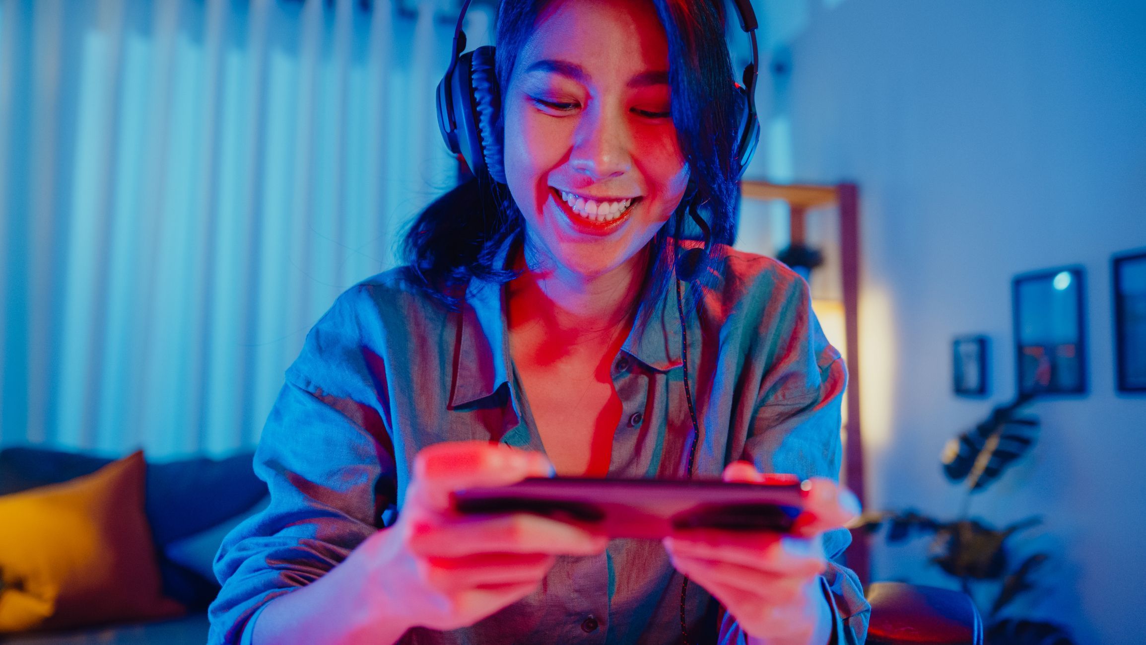 Happy asia girl gamer wear headphone competition play video game online