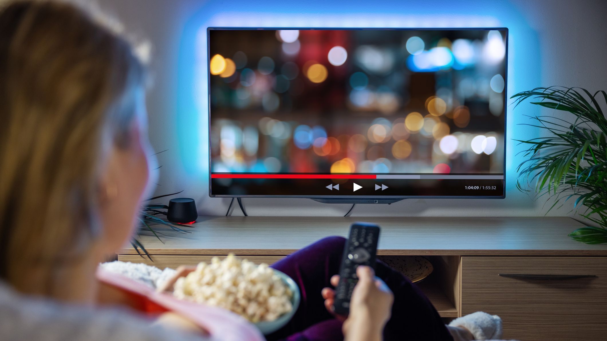 Woman relaxing at home in evening and watching TV