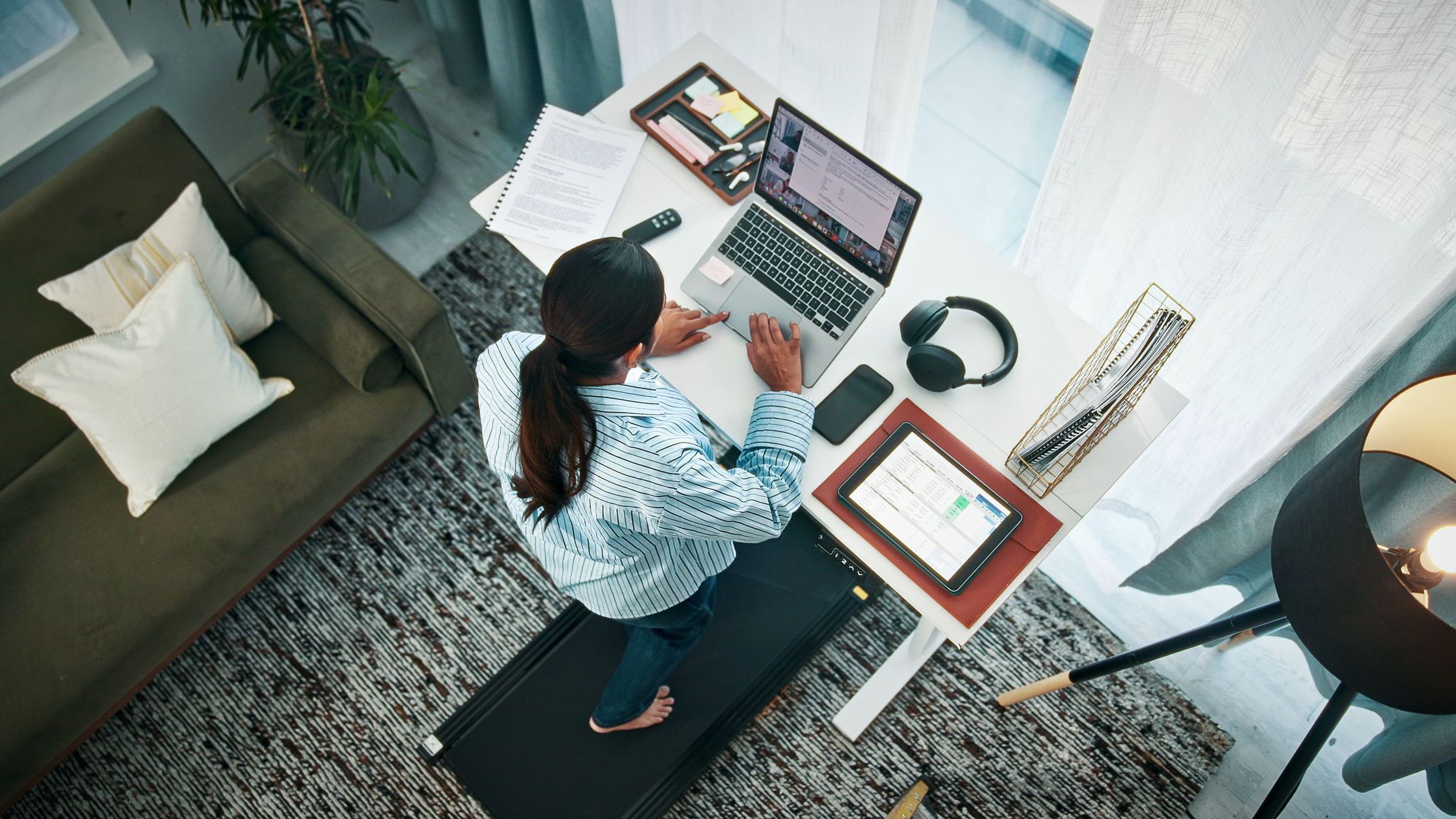 Woman, treadmill or typing with laptop on standing desk above for productive day in home